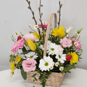 Basket arrangement of daisies, tulips, and pink blooms with pussy willow stems