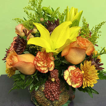Bouquet of yellow lilies, orange roses, and carnations in a turkey-shaped container