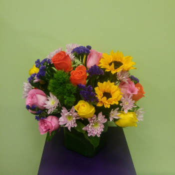 Mixed bouquet of roses, sunflowers, and small purple daisies