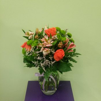 Orange roses and pink alstroemeria in a glass vase