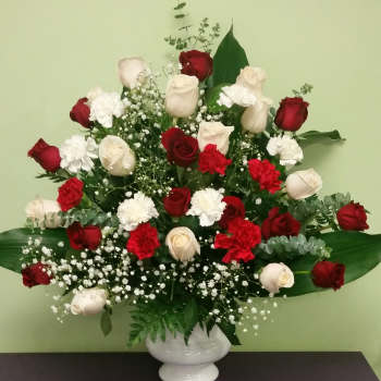 Red and white roses with carnations in a white vase