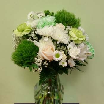 Bouquet of white and green flowers in a clear glass vase