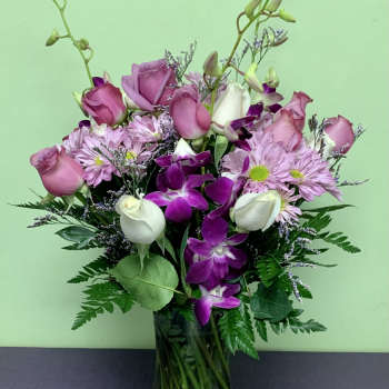Pink roses and purple orchids in a glass vase