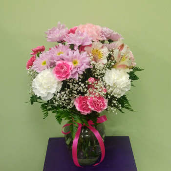 Pink and white mixed bouquet in a glass vase with a ribbon