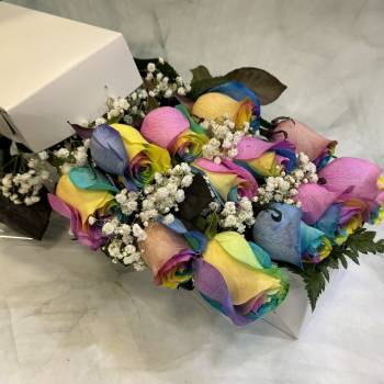 Bouquet of rainbow-colored roses with baby's breath in a white box