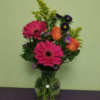 Pink gerbera daisies and orange roses in a glass vase