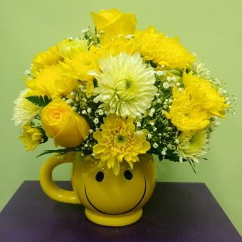 Yellow flower bouquet in a smiley-face mug vase
