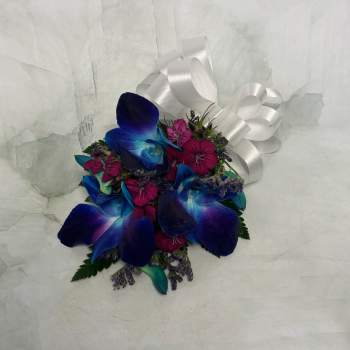 Small bouquet of blue orchids and pink flowers with a white ribbon