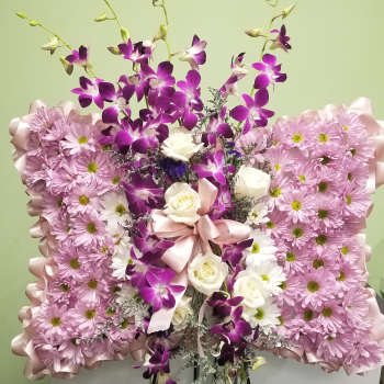 Pink and purple floral standing arrangement with white roses on an easel