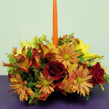 Autumn floral centerpiece with an orange taper candle