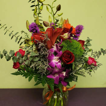 Mixed bouquet in a glass vase with red, purple, and orange flowers