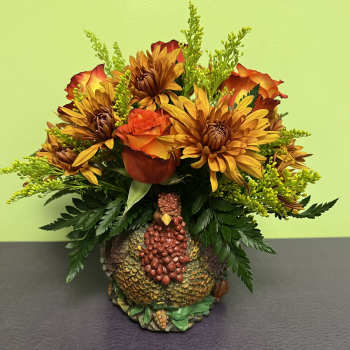 Autumn bouquet with orange roses and yellow chrysanthemums in a turkey vase