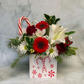 Holiday floral arrangement in a candy cane box with red and white flowers