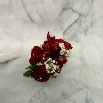 Red rose corsage with white baby's breath and a burgundy ribbon