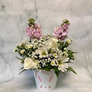 Pink and white flowers arranged in a bunny-decorated bucket