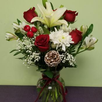 Bouquet of red roses and white lilies in a glass vase