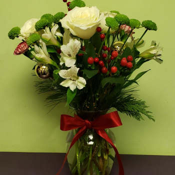 Bouquet of white roses and alstroemeria in a glass vase with a red ribbon
