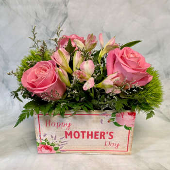 Low box arrangement of pink roses and alstroemeria with green accents in a Happy Mother's Day container.