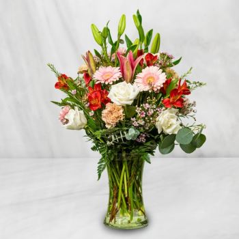 Mixed bouquet of lilies, roses, gerbera daisies, and alstroemeria in a glass vase