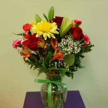 Mixed bouquet of red and yellow flowers in a glass vase
