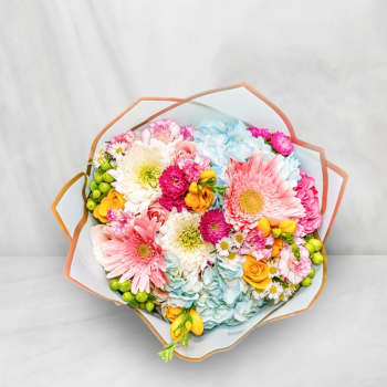 Colorful bouquet with gerbera daisies, roses, and hydrangeas wrapped in paper