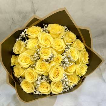 Bouquet of yellow roses with white filler flowers in brown wrap