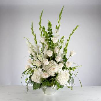 Tall white floral arrangement in a white bowl vase