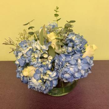 Blue hydrangea bouquet with white roses in a glass vase