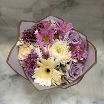 Bouquet of pink and lavender flowers with cream blooms in paper wrap