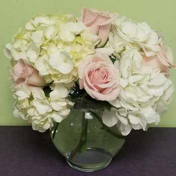 Pink roses and white hydrangeas in a clear glass vase