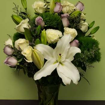 White lilies and pale roses in a glass vase