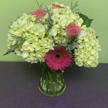 Pink and white flowers arranged in a glass vase