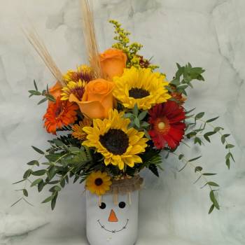 Sunflower and rose arrangement in a snowman vase