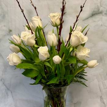White tulips and roses in a clear glass vase