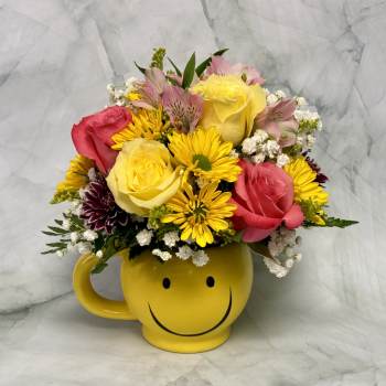 Mixed bouquet in a yellow smiley-face mug