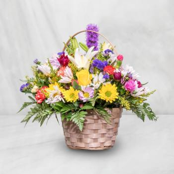 Mixed flower basket with daisies, lilies, and roses in a woven basket