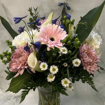 Mixed bouquet in a clear glass vase with pink gerberas and white calla lilies