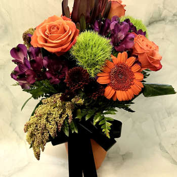 Bouquet of orange roses and purple flowers with a black ribbon