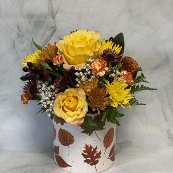 Yellow roses and mixed chrysanthemums in a leaf-patterned box