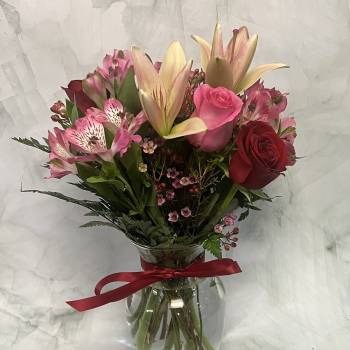 Bouquet of pink lilies, roses, and alstroemeria in a glass vase