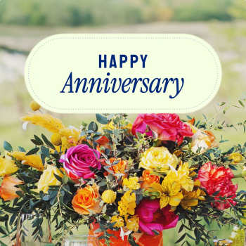 Colorful bouquet with roses and yellow flowers under a Happy Anniversary sign