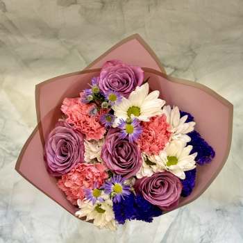 Bouquet of purple roses, pink carnations, and white daisies in pink wrap