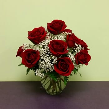 Red roses and white baby's breath in a clear glass vase