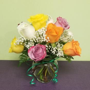 Mixed roses in a clear glass vase with baby's breath