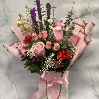 Pink rose bouquet in a gift bag with ribbon