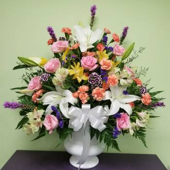 Mixed bouquet in a white vase with pink roses and white lilies
