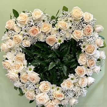 Heart-shaped floral wreath of cream roses and white filler flowers