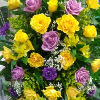 Tall bouquet of yellow and lavender roses with purple accents