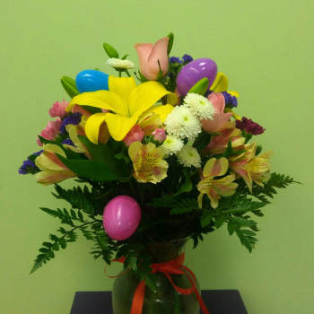 Colorful bouquet in a green vase with decorative plastic eggs