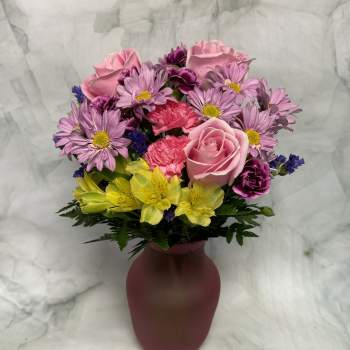 Pink and purple mixed bouquet in a burgundy vase